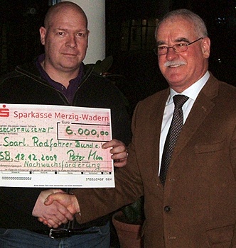 Lutz Drehkopf (links) erhält von Peter Koch (rechts) einen Scheck über 6000 Euro für die Nachwuchsarbeit im Saarländischen Radfahrer-Bund. Foto: Jörg Aumann